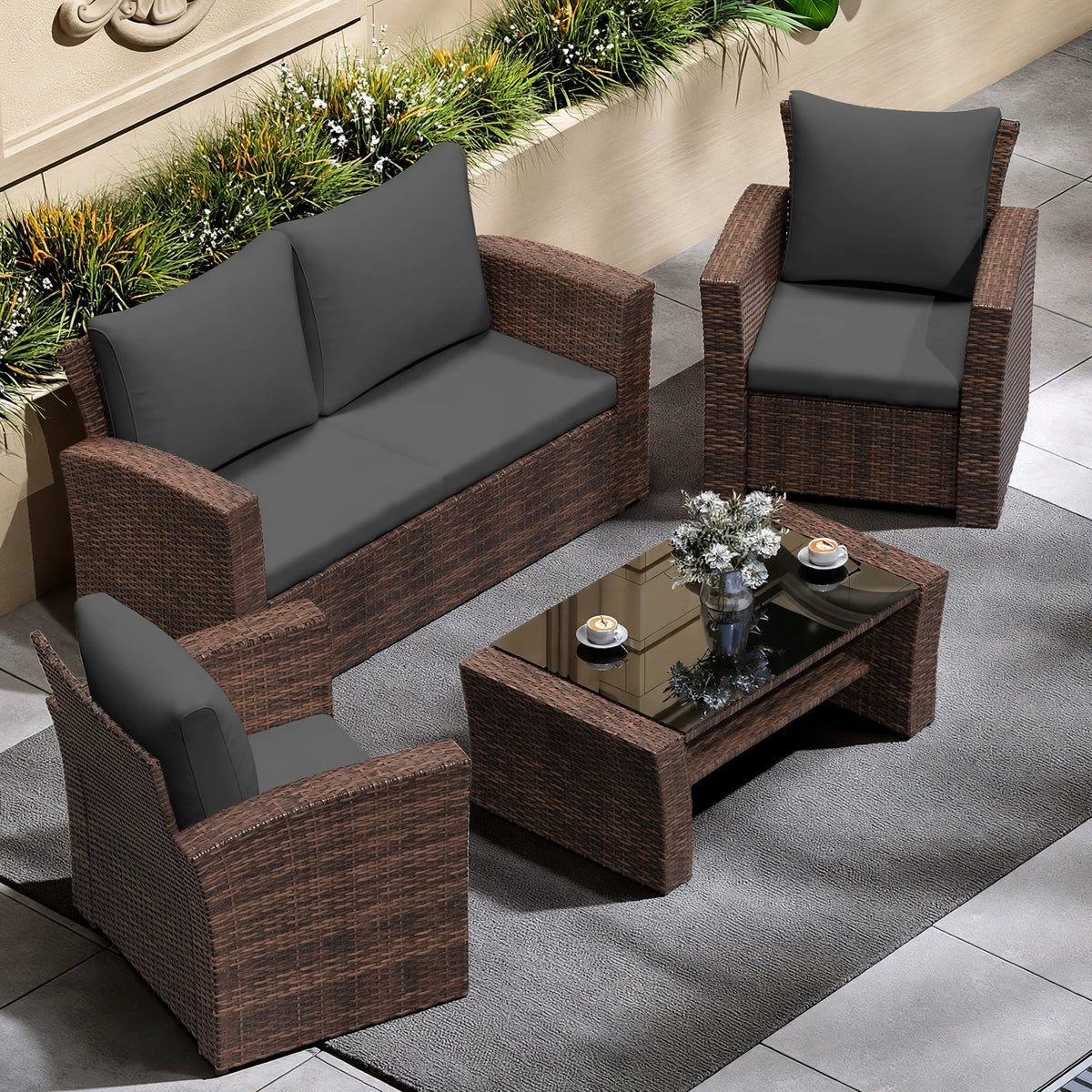 Overhead view of 4-piece espresso brown rattan patio set with charcoal cushions and glass coffee table on modern patio