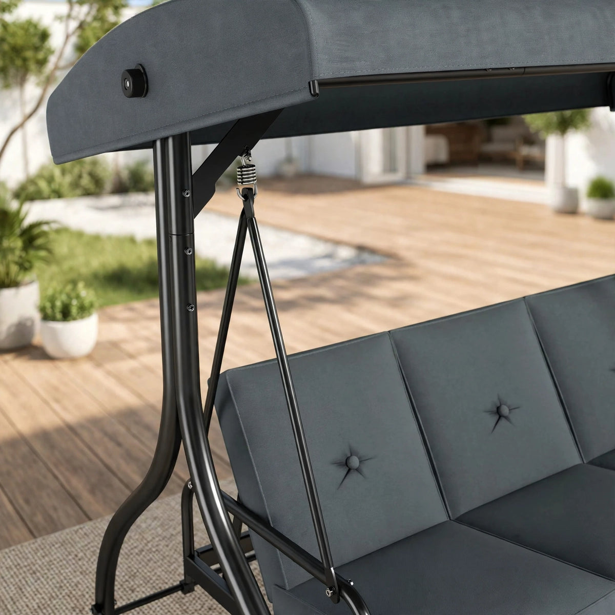 Close-up of charcoal gray patio swing showing tufted cushions, powder-coated steel frame and adjustable canopy spring mechanism on modern deck